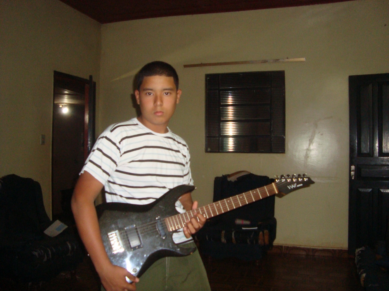 Pedro ainda jovem segurando a guitarra preta no início de sua história com o instrumento