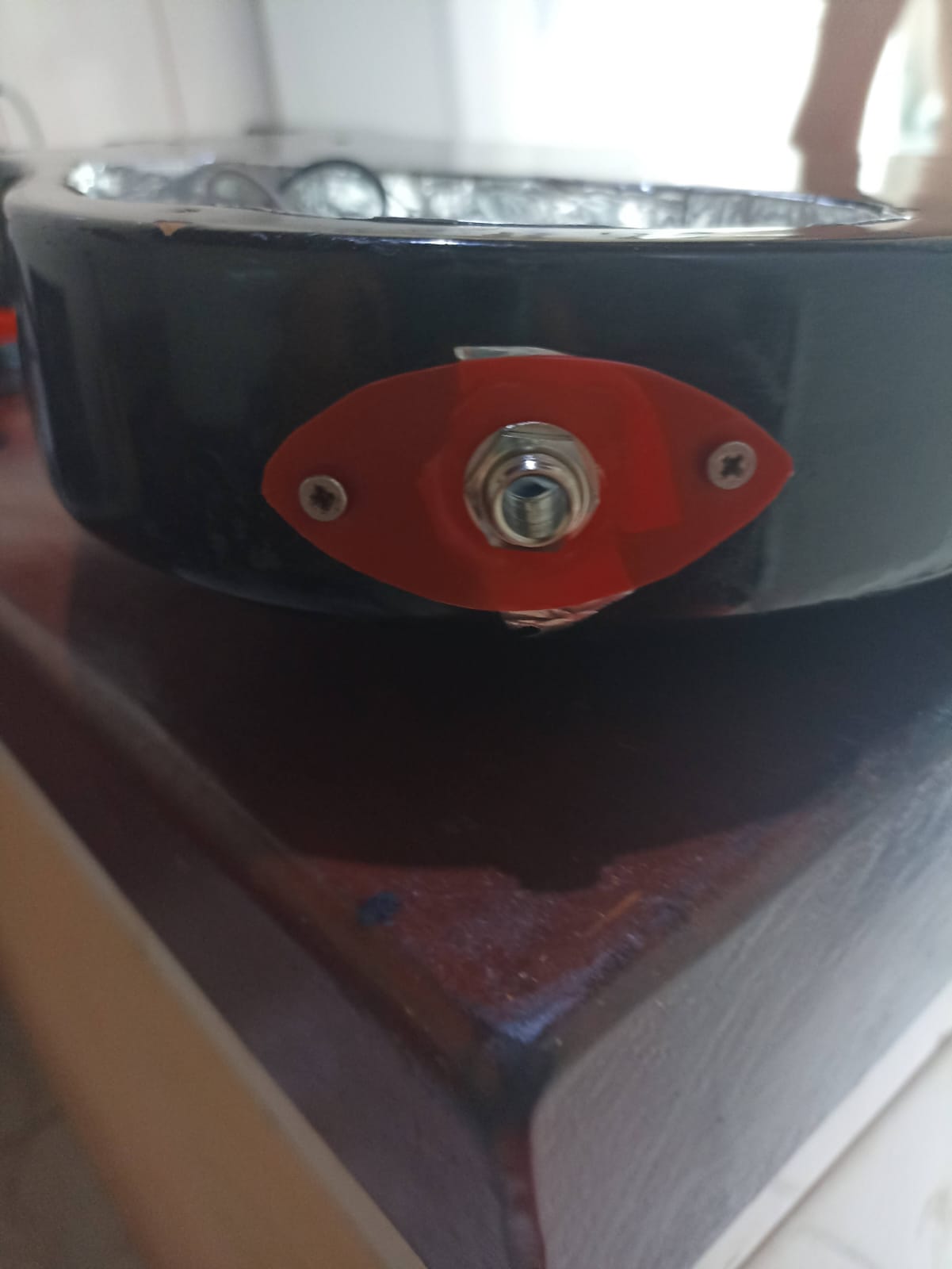 Jack da guitarra instalado em uma peça vermelha recortada de tampa de margarina