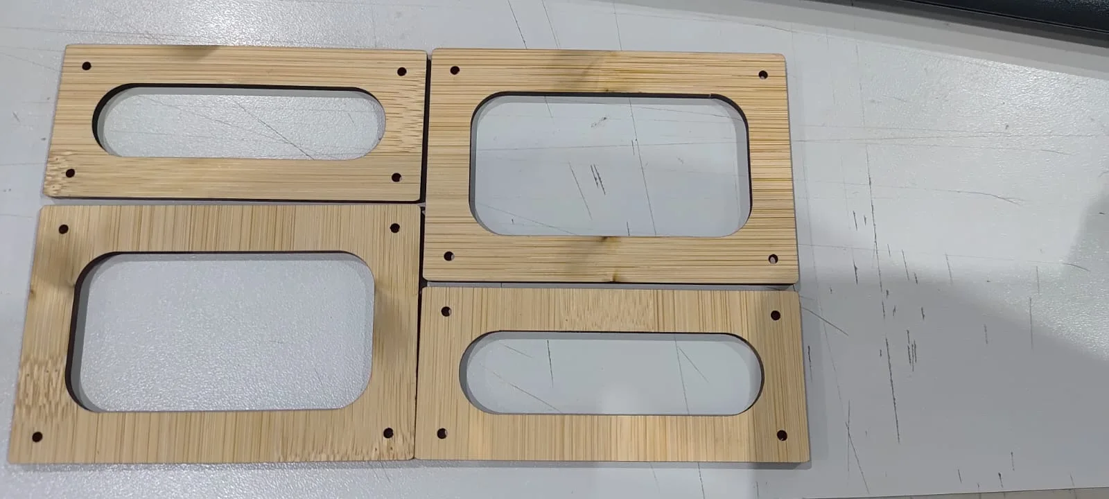 Quatro peças de bambu cortadas a laser para formar duas molduras de captadores por sobreposição em pares