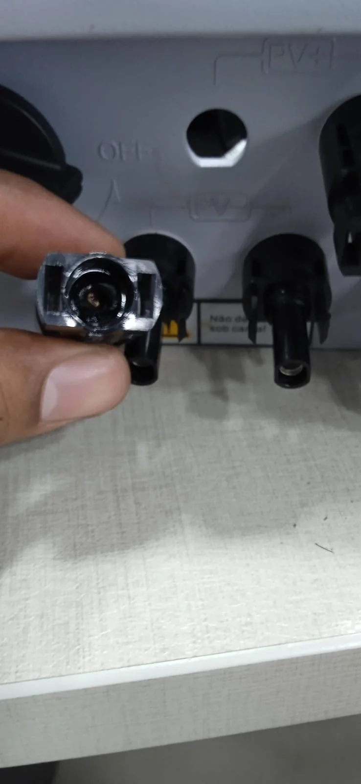 Conector fotovoltaico danificado do inversor 2 diante do painel de conexões